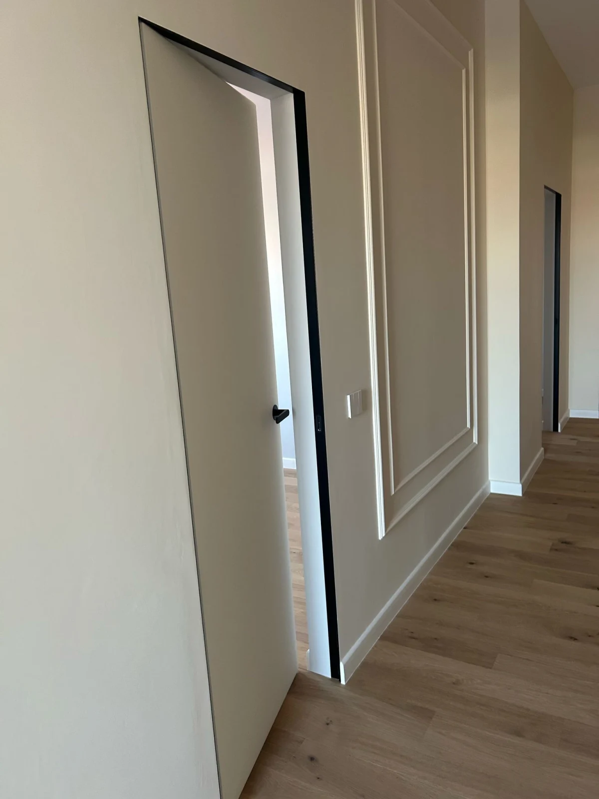 Foaie filomuro deschisă pe parchet, lângă perete cu profile decorative care trebuie protejat de impact