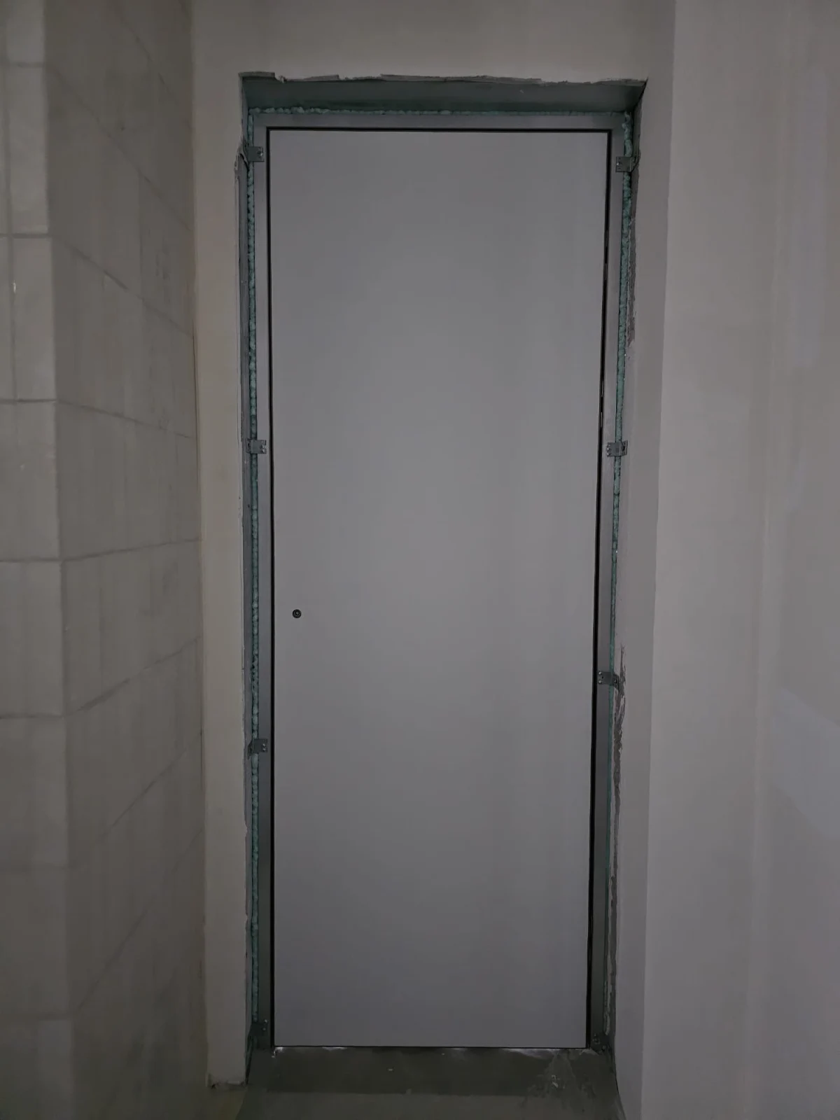 Toc filomuro din aluminiu montat în roșu, înainte de tencuială și faianță, cu bordura încă descoperită